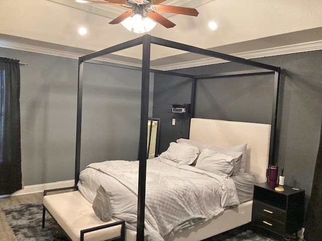 bedroom featuring wood-type flooring, ornamental molding, and ceiling fan