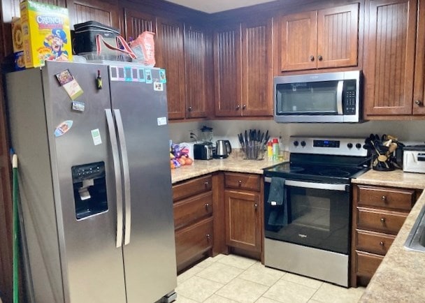 kitchen featuring stainless steel appliances and light tile patterned flooring