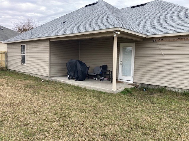 rear view of house with a lawn and a patio