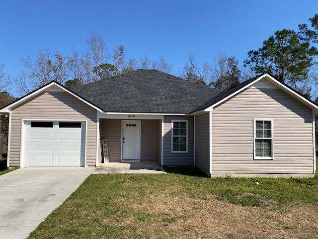 ranch-style house with a garage, driveway, a shingled roof, and a front yard