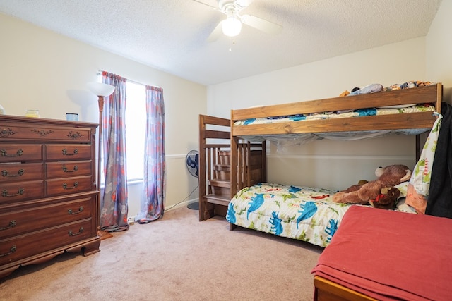 carpeted bedroom featuring ceiling fan and a textured ceiling