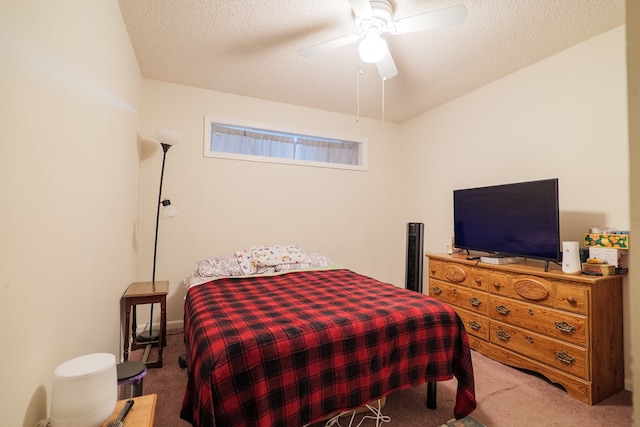 carpeted bedroom featuring ceiling fan and a textured ceiling