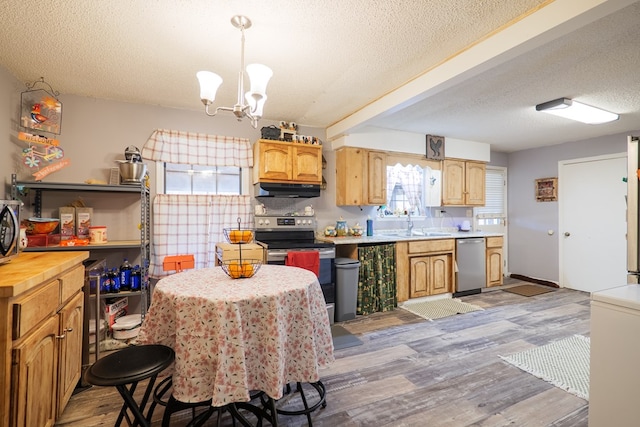 kitchen featuring an inviting chandelier, appliances with stainless steel finishes, hardwood / wood-style floors, and pendant lighting