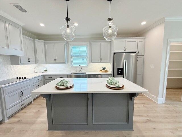 4965 Hatfield Cir, Hahira, GA 31632 - kitchen featuring stainless steel appliances, a sink, light countertops, crown molding, and backsplash