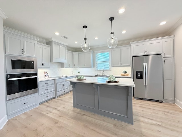 4965 Hatfield Cir, Hahira, GA 31632 - kitchen with stainless steel appliances, ornamental molding, light countertops, a center island, and tasteful backsplash