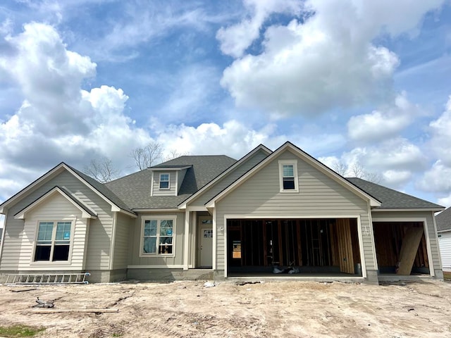 view of front of property featuring a garage and roof with shingles