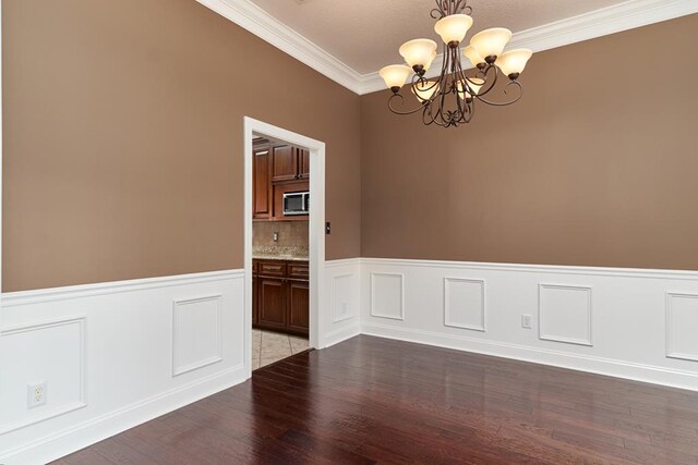 5527 School House Pond Rd, Lake Park, GA 31636 - unfurnished room featuring a chandelier, wood finished floors, ornamental molding, a wainscoted wall, and a decorative wall
