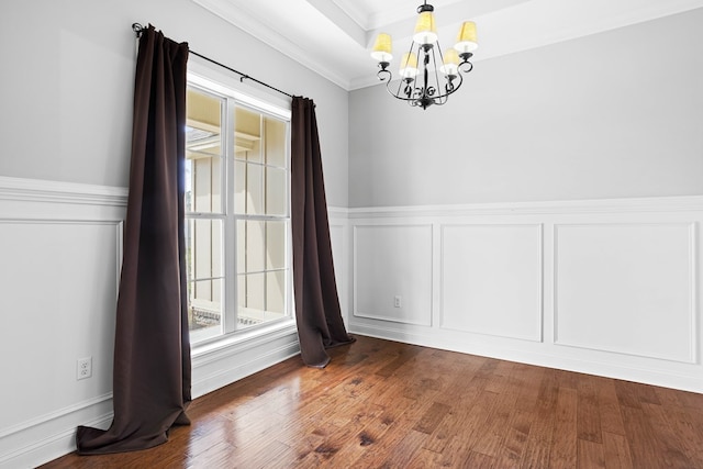 unfurnished dining area with crown molding, a decorative wall, a wealth of natural light, and wood finished floors