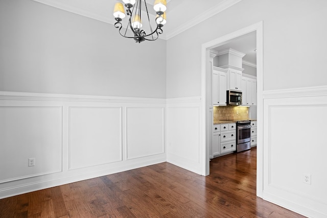 unfurnished dining area with ornamental molding, a chandelier, dark wood-style flooring, and a decorative wall