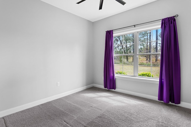 empty room with carpet flooring, a ceiling fan, and baseboards