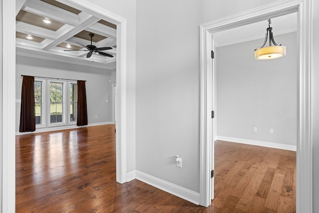 spare room with beam ceiling, hardwood / wood-style floors, ornamental molding, coffered ceiling, and baseboards