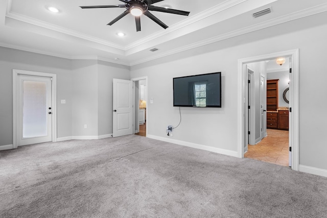 unfurnished bedroom with crown molding, a raised ceiling, visible vents, and light colored carpet