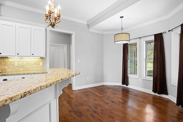 kitchen featuring crown molding, tasteful backsplash, dark wood-type flooring, white cabinetry, and light stone countertops