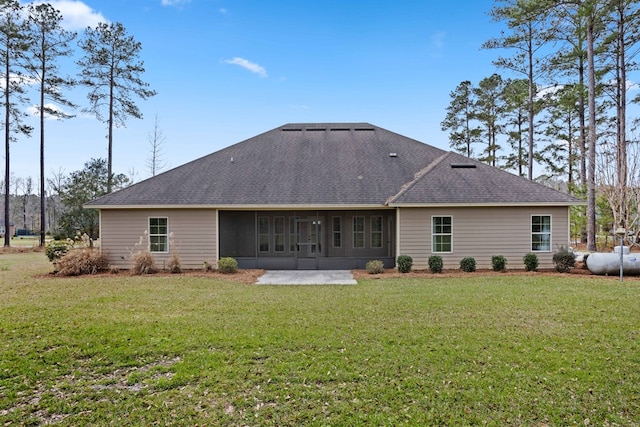 back of property featuring roof with shingles and a yard