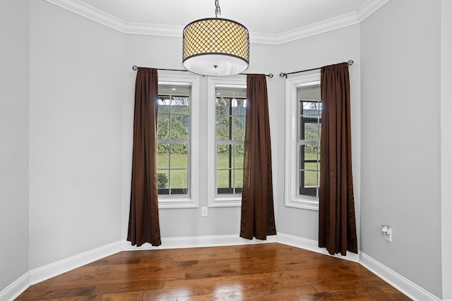 spare room with ornamental molding, baseboards, and hardwood / wood-style floors