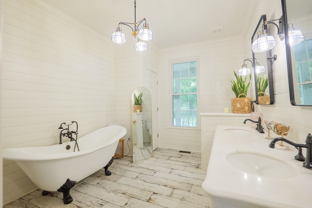 7552 Webb Rd, Hahira, GA 31632 - bathroom featuring ornamental molding, a freestanding tub, double vanity, and wood finished floors