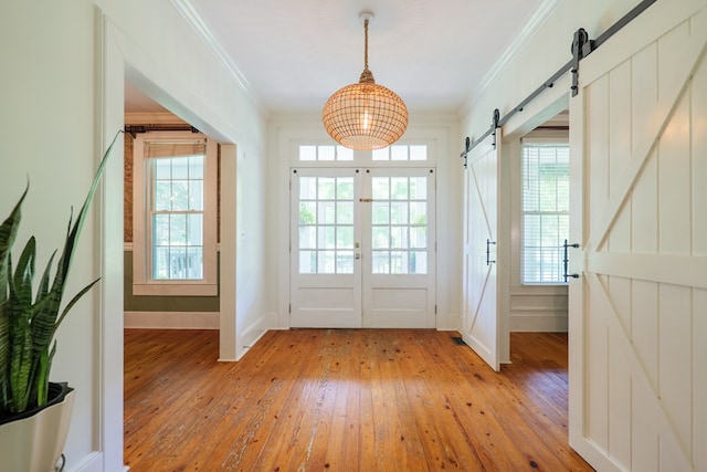 7552 Webb Rd, Hahira, GA 31632 - doorway with a barn door, light wood finished floors, crown molding, plenty of natural light, and french doors