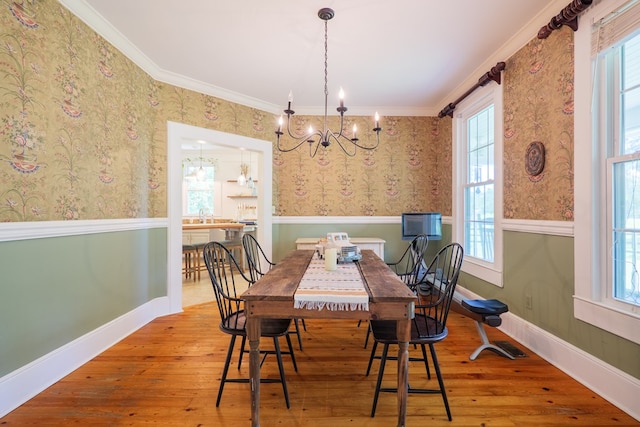 7552 Webb Rd, Hahira, GA 31632 - dining area with a chandelier, a wainscoted wall, wallpapered walls, wood-type flooring, and crown molding