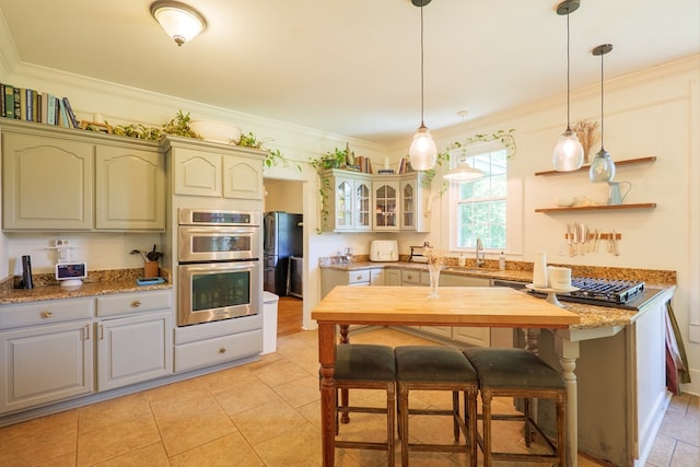 7552 Webb Rd, Hahira, GA 31632 - kitchen featuring stainless steel appliances, crown molding, pendant lighting, glass insert cabinets, and light stone countertops