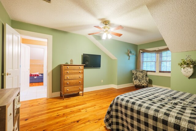 7552 Webb Rd, Hahira, GA 31632 - bedroom with a textured ceiling, light wood-style floors, ceiling fan, vaulted ceiling, and a walk in closet