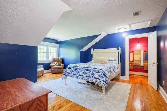 7552 Webb Rd, Hahira, GA 31632 - bedroom with a textured ceiling, hardwood / wood-style flooring, vaulted ceiling, and attic access