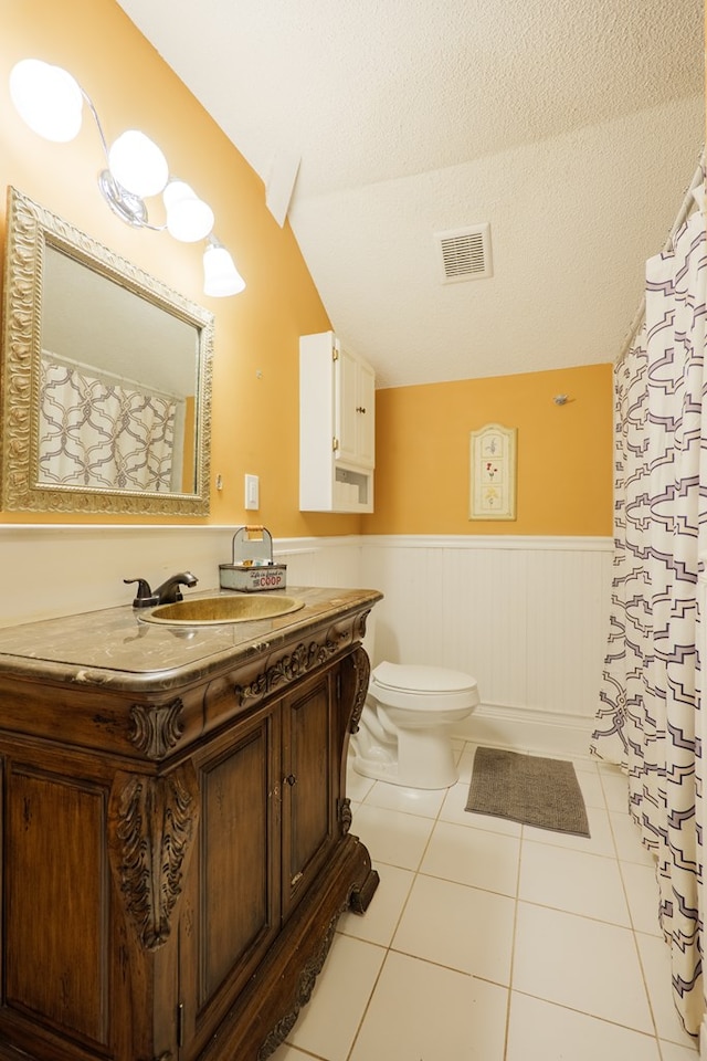 7552 Webb Rd, Hahira, GA 31632 - full bath featuring vaulted ceiling, a wainscoted wall, vanity, tile patterned floors, and a textured ceiling