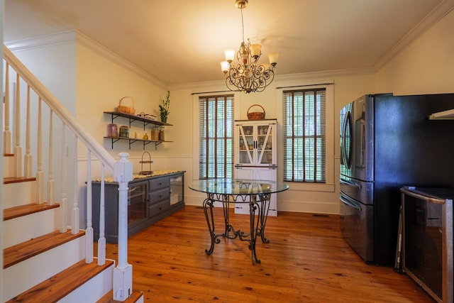 7552 Webb Rd, Hahira, GA 31632 - dining space featuring stairs, hardwood / wood-style flooring, a chandelier, and crown molding
