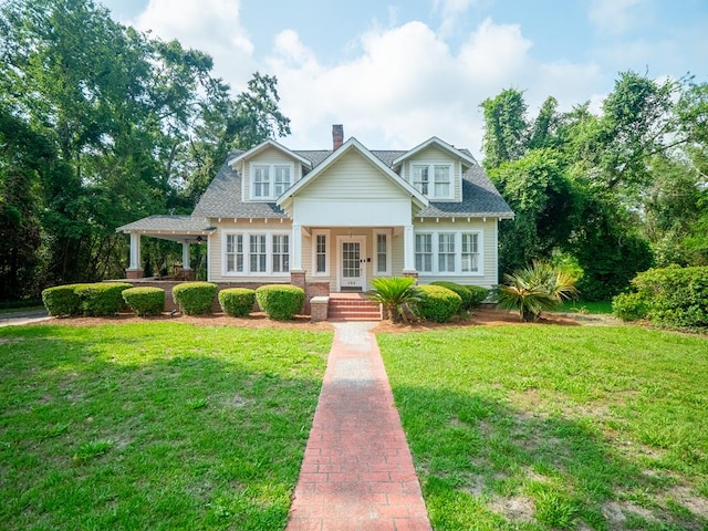 103 W Moore St, Valdosta, GA 31602 - traditional-style home featuring covered porch, a chimney, a front lawn, and a shingled roof