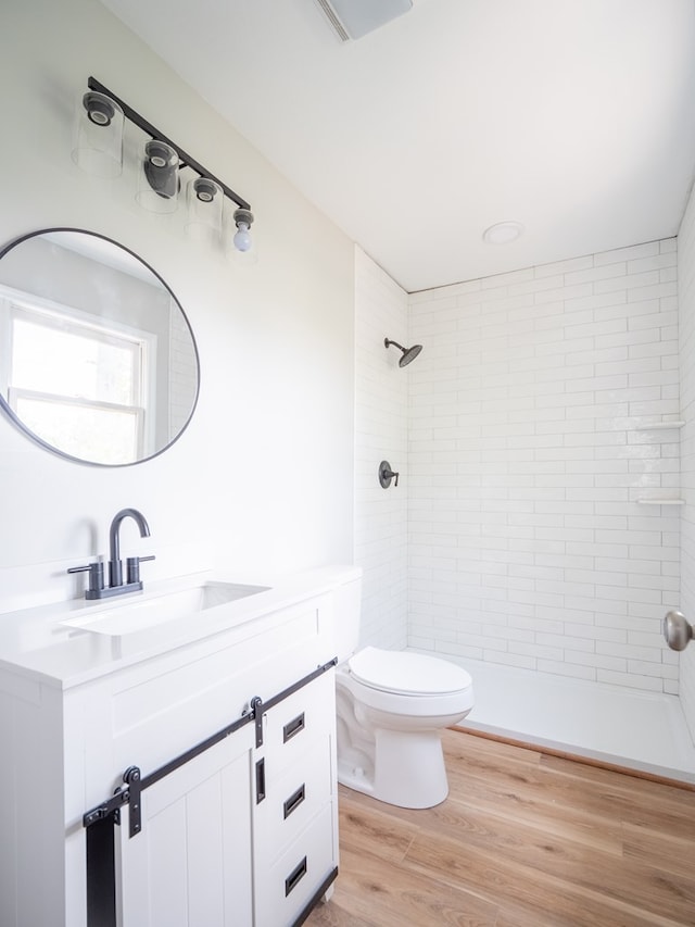 103 W Moore St, Valdosta, GA 31602 - full bath with toilet, vanity, tiled shower, and wood finished floors