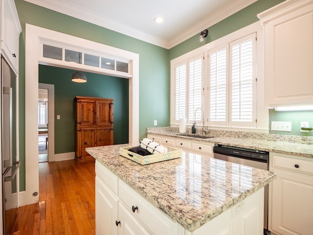 103 W Moore St, Valdosta, GA 31602 - kitchen featuring a sink, a kitchen island, light wood-type flooring, ornamental molding, and light stone countertops
