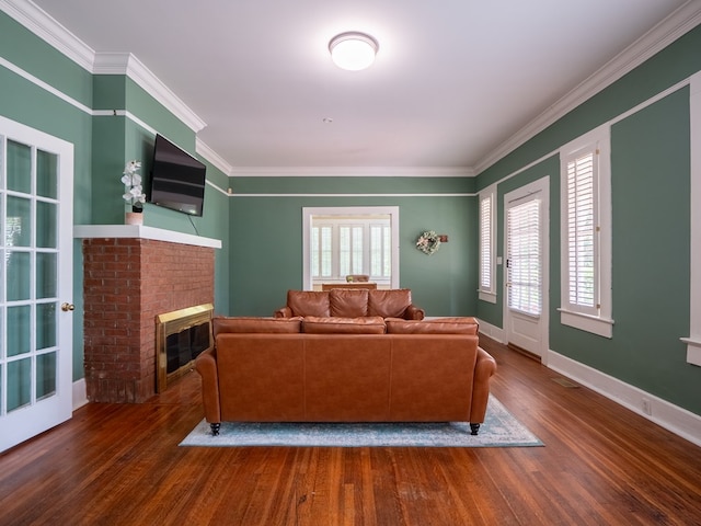 103 W Moore St, Valdosta, GA 31602 - living room featuring wood finished floors, a brick fireplace, crown molding, and baseboards