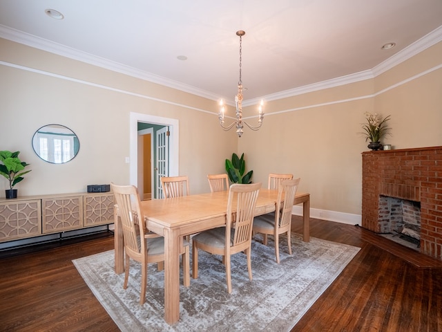103 W Moore St, Valdosta, GA 31602 - dining space with wood finished floors, a chandelier, crown molding, baseboards, and a brick fireplace