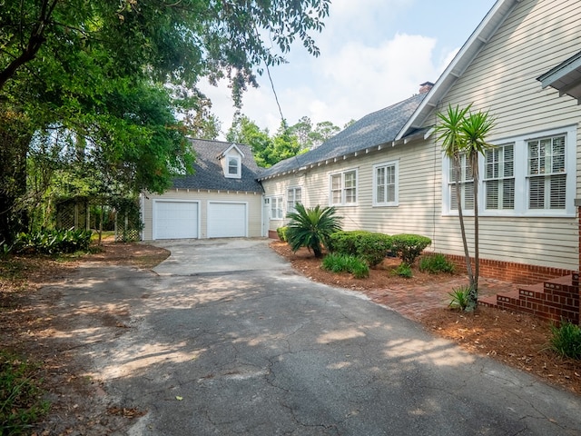 103 W Moore St, Valdosta, GA 31602 - view of front of home featuring asphalt driveway, a chimney, an outdoor structure, and a shingled roof