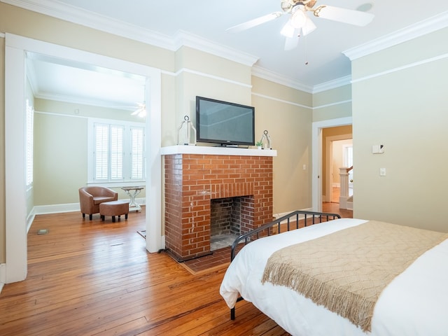 103 W Moore St, Valdosta, GA 31602 - bedroom featuring ornamental molding, wood-type flooring, a brick fireplace, baseboards, and ceiling fan