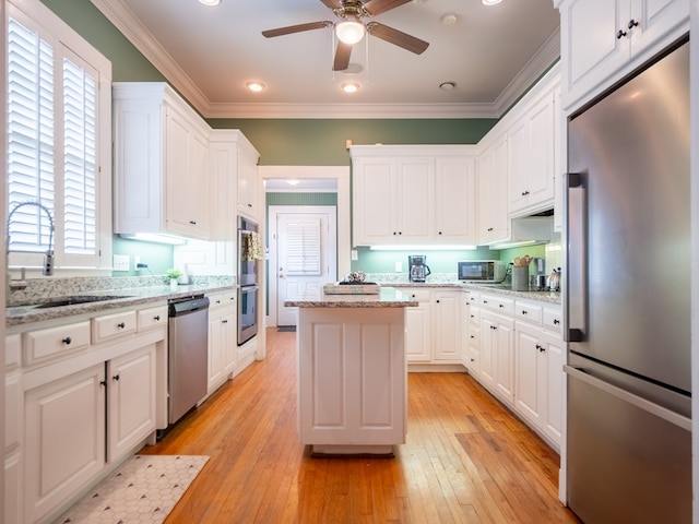 103 W Moore St, Valdosta, GA 31602 - kitchen with stainless steel appliances, a sink, white cabinets, ceiling fan, and a center island