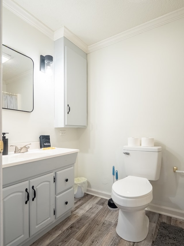 103 W Moore St, Valdosta, GA 31602 - bathroom with wood finished floors, crown molding, toilet, vanity, and baseboards
