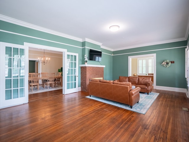 103 W Moore St, Valdosta, GA 31602 - living room featuring crown molding, a chandelier, hardwood / wood-style flooring, and baseboards