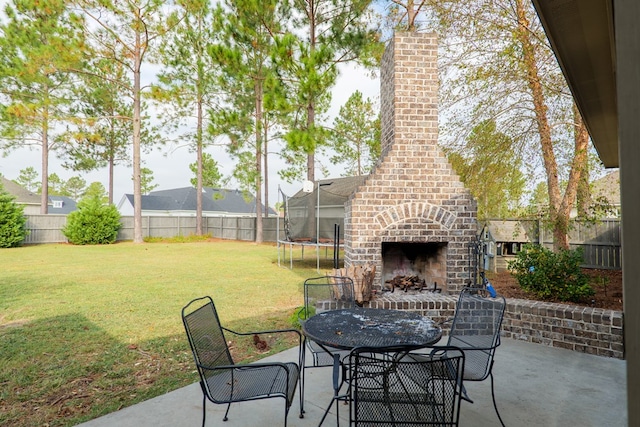 7351 Woodbend Trl, Hahira, GA 31632 - fenced backyard with an outdoor brick fireplace, a patio, a trampoline, and outdoor dining area