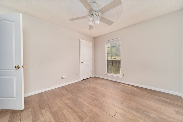 spare room with ceiling fan, a textured ceiling, and light hardwood / wood-style flooring