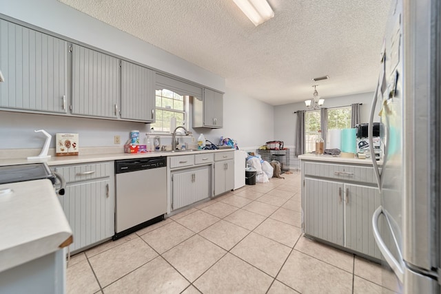 kitchen featuring stainless steel fridge, a textured ceiling, pendant lighting, an inviting chandelier, and dishwasher