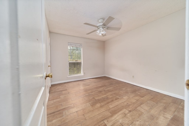 unfurnished room with a textured ceiling, light wood-type flooring, and ceiling fan