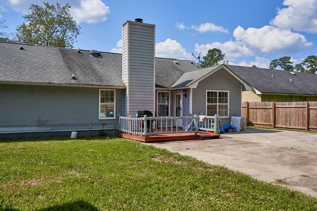 rear view of property with a yard, a patio area, and a wooden deck