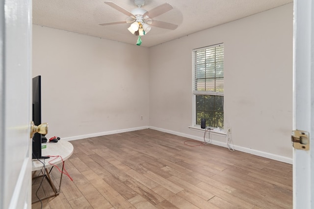 unfurnished room featuring ceiling fan, light wood-type flooring, and a textured ceiling