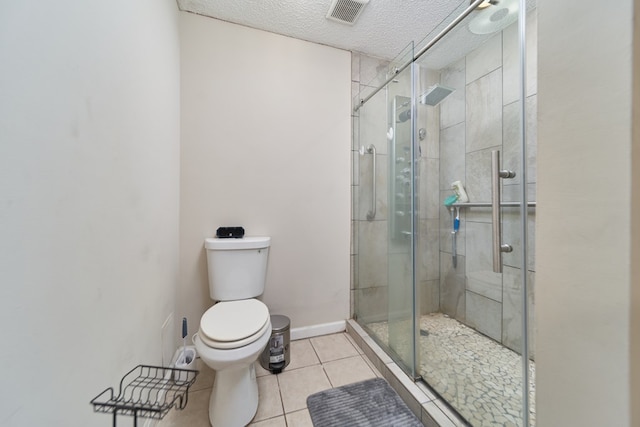 bathroom with toilet, a textured ceiling, tile patterned floors, and a shower with shower door