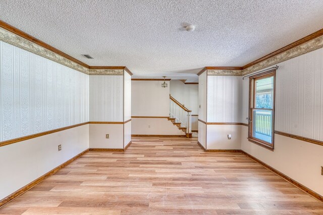 dining room featuring french doors, a textured ceiling, ornamental molding, and a notable chandelier