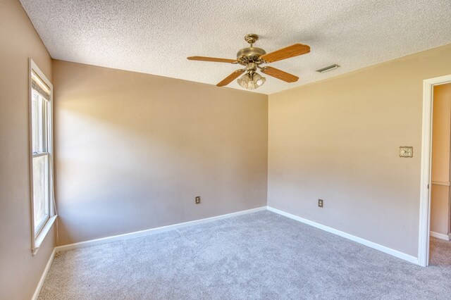 carpeted bedroom featuring ceiling fan and a textured ceiling