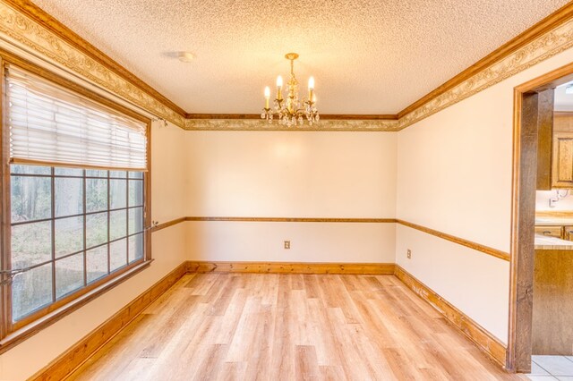 dining space featuring wood-type flooring, a textured ceiling, ornamental molding, and a notable chandelier