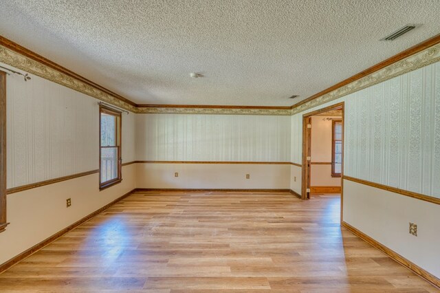 unfurnished living room featuring a textured ceiling, crown molding, wood-type flooring, and a fireplace