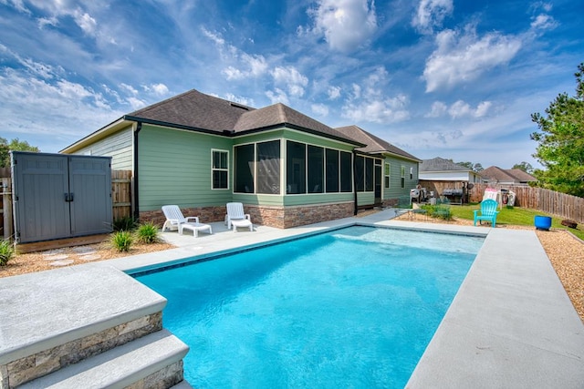 view of pool featuring a sunroom, a patio, a fenced in pool, and a fenced backyard