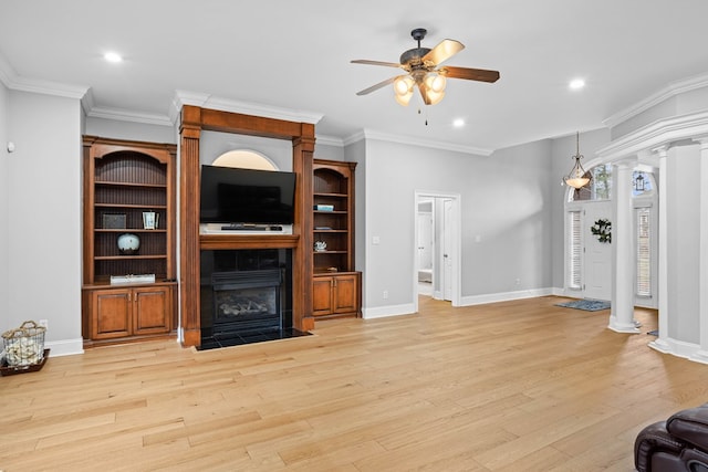 living room with decorative columns, a fireplace, ceiling fan, and light hardwood / wood-style flooring